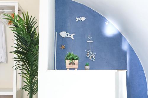 una camera con una parete blu e una pianta di Naboo Guest House - Amalfi Coast a Salerno