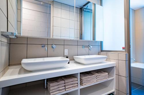 a bathroom with two sinks and a mirror at シースペースロード SeaSpaceRoad in Onna