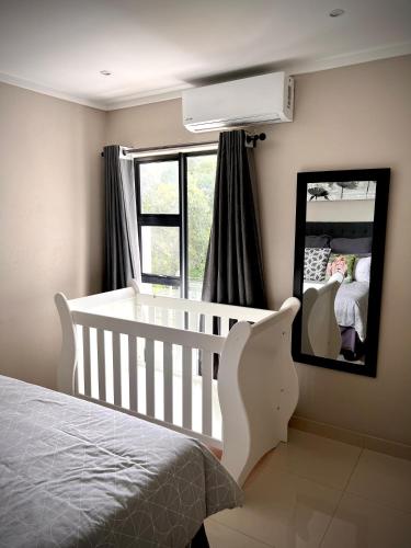 a white crib in a bedroom with a mirror at No Load-Shedding Holiday Home in Mataffin