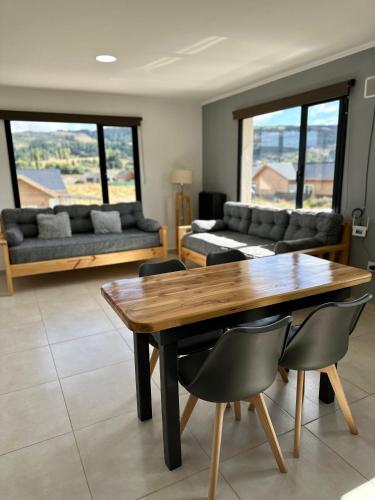 a living room with a wooden table and chairs at Hábitat 268 in Esquel