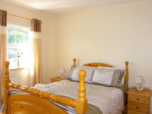 a bedroom with a wooden bed with two night stands at Fermanagh Holiday Home in Newtown Butler