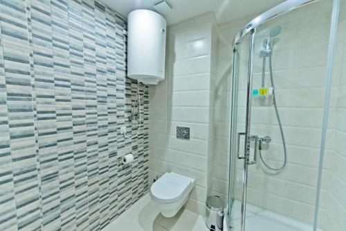 a bathroom with a toilet and a glass shower at Hotel 19 Batumi in Batumi
