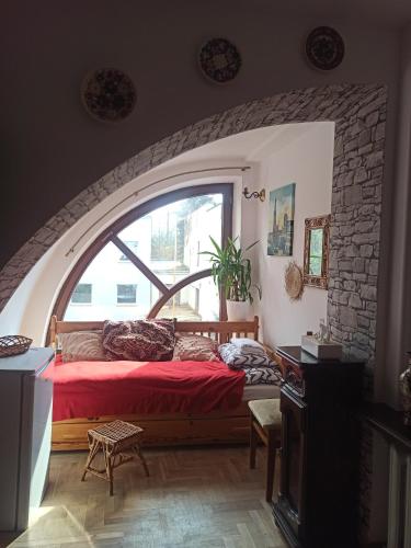 a bedroom with a red bed in front of a window at Hotel-hostel Saska in Warsaw