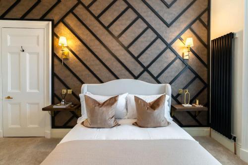 a bedroom with a white bed with a wooden wall at The Devonshire Suite - Your 5 STAR West End Stay! in Glasgow