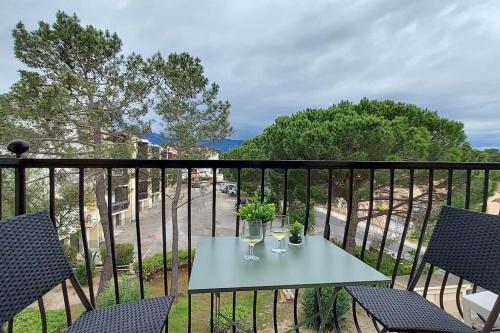 - une table avec deux verres de vin sur le balcon dans l'établissement Appartement rénové avec balcon à 100 m de la plage, à Argelès-sur-Mer