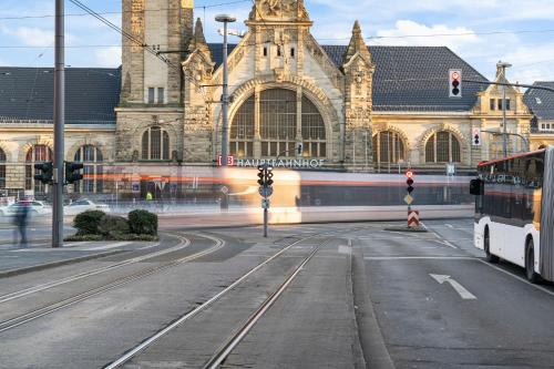 a train traveling past a large building with a street at APARTVIEW Apartments Krefeld - WLAN - Zentral - ruhig in Krefeld