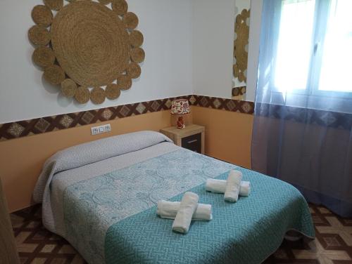 1 dormitorio con 1 cama con toallas en Conjunto Rural Andrea, en Moriles