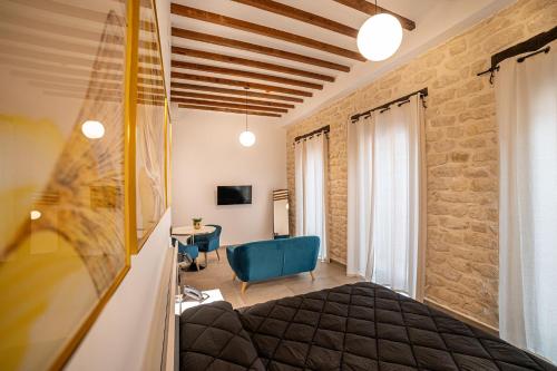 a bedroom with a bed and a blue chair at Apartamentos Loliqui centro Alicante in Alicante