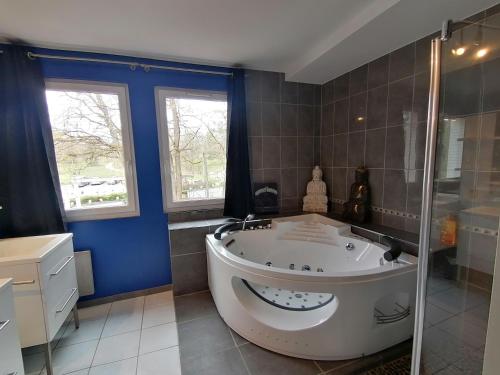 baño grande con bañera y ventana en L'Odyssée VILLA ILOA, en Dommartemont