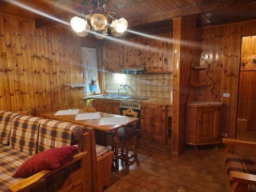 a kitchen with wooden walls and a table and a stove at MONTAGNA CHE PASSIONE in Chiomonte