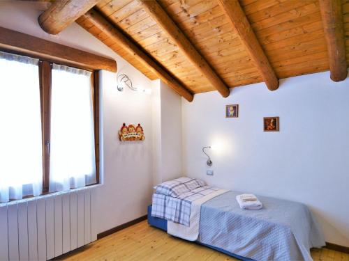 a bedroom with a bed and a large window at Lovely holiday home in Valbondione with balcony in Valbondione