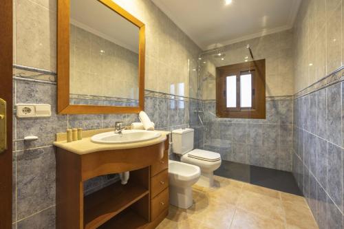 a bathroom with a sink and a toilet and a mirror at Villa El Mal Pas / Can Seguinet in Alcudia
