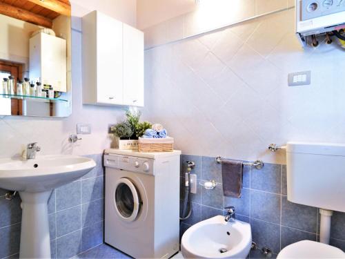 ein Badezimmer mit einer Waschmaschine und einem Waschbecken in der Unterkunft Lovely holiday home in Valbondione with balcony in Valbondione