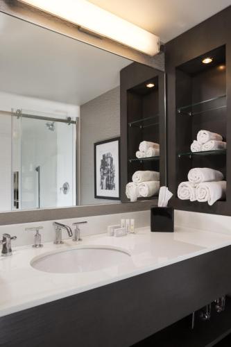 a bathroom with a sink and a mirror and towels at Courtyard by Marriott Minneapolis Downtown in Minneapolis