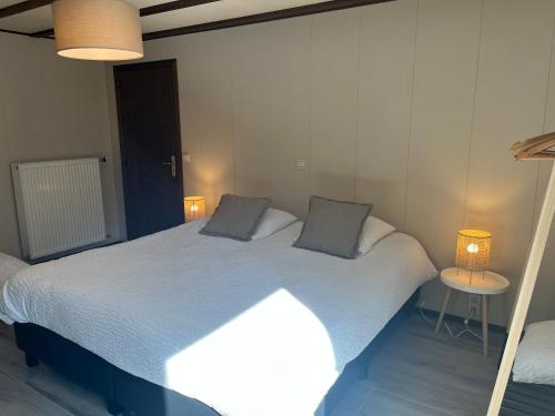 um quarto com uma cama grande e 2 almofadas em Auberge du Carrefour Chez Odille em Vielsalm