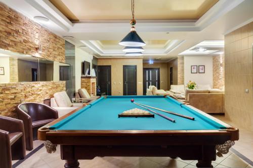 a pool table in a living room with pool sticks at Congress Hotel Malakhit in Chelyabinsk