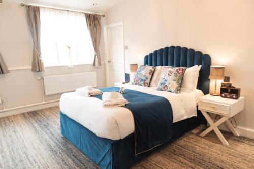 a bedroom with a large bed with a blue headboard at The Royal Kings Arms in Lancaster