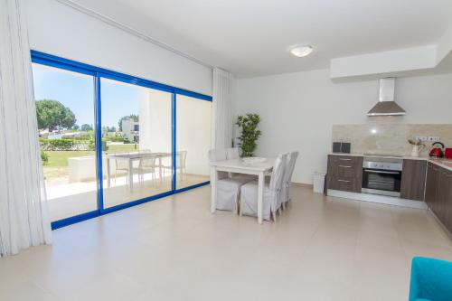 a kitchen and dining room with a table and chairs at Apartamentos Clube da Bemposta in Alvor