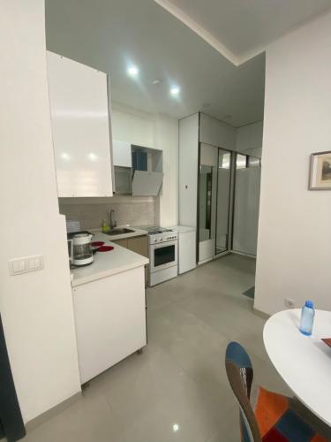 a kitchen with white cabinets and a table in a room at Studio Très Moderne Gallo 1 - Mamelles Dakar in Dakar