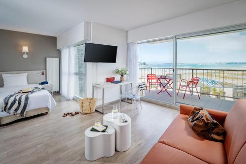 a hotel room with a bed and a balcony at Hôtel Valdys Thalasso & Spa - Beau rivage in Roscoff