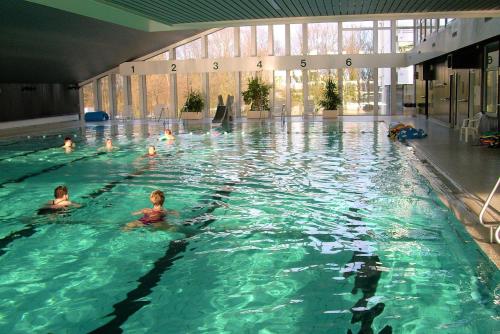 eine Gruppe von Personen, die in einem Schwimmbad schwimmen in der Unterkunft Panoramic App A03-1 in Sierksdorf