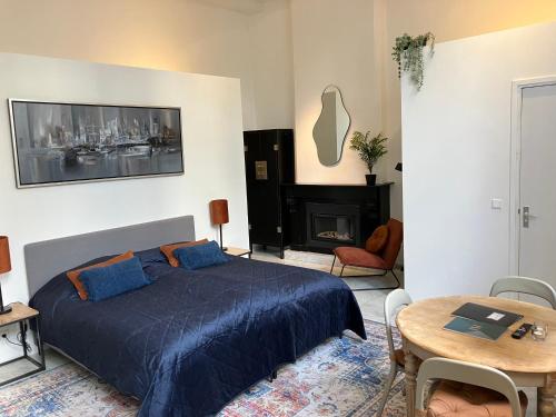 1 dormitorio con cama, mesa y chimenea en Galerie Hotel Dis en Maastricht