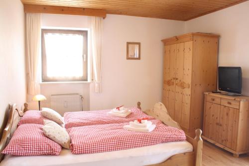 1 dormitorio con 1 cama con 2 toallas en Almberghütte, en Philippsreut