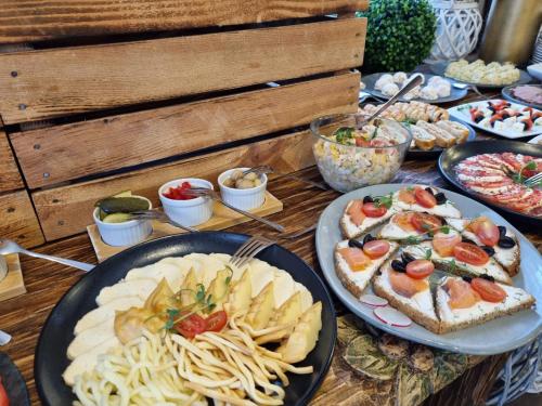 a table topped with plates of food and pasta at Willa Silene - góralska muzyka na żywo, blisko Term i wyciągów narciarskich in Bukowina Tatrzańska