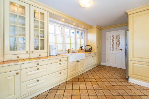 a kitchen with white cabinets and a sink at Landhaus Nici in Westerland (Sylt)