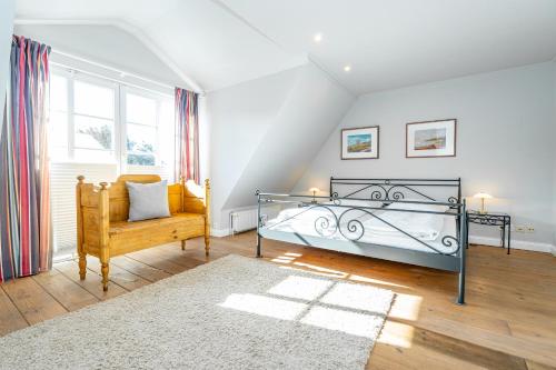 a bedroom with a bed and a chair at Landhaus Nici in Westerland (Sylt)