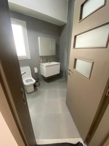 bagno con servizi igienici, lavandino e porta di Apt De Luxe Gallo 2 - Mamelles Dakar a Dakar