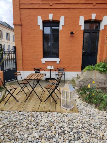 a patio with chairs and a table in front of a building at La Baigneuse maison avec jardinet et parking privé, à 200 m plage in Cayeux-sur-Mer