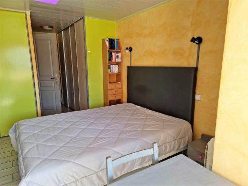 um quarto com uma cama num quarto com paredes verdes em Studios Village Naturiste Port Venus Enigma & Studio Port Soleil Orchidée em Cap d'Agde