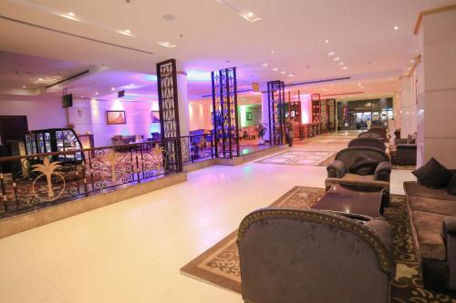 a lobby with couches and a bar in a building at Reef Global Hotel in Makkah