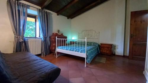 una camera con letto, finestra e divano di vallemaira house GRAN BAITA gruppi 4-14 persone a San Damiano Macra