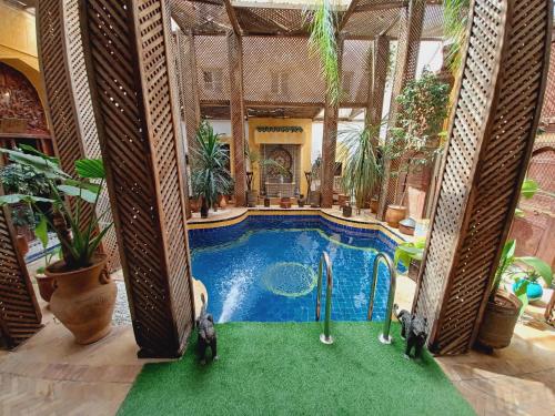 una piscina en una casa con dos palos de golf en Palais Al Firdaous, en Fez