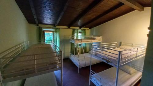 a room with three bunk beds in it at vallemaira house GRAN BAITA 12 posti letto in exclusiva da 2 persone in San Damiano Macra