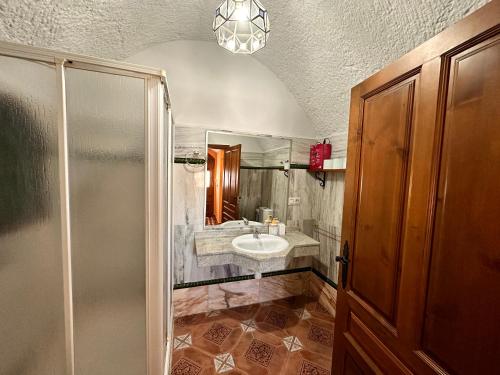 un baño con lavabo y ducha en Cuevas La Granja, en Benalúa de Guadix