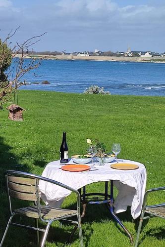 una mesa con una botella de vino y dos sillas en Villa Acces Direct A La Mer Liliy the sea, en Gâvres