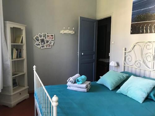 a bedroom with a blue bed with towels on it at Maison d'Hôtes La Bastide Bleue in Marseille