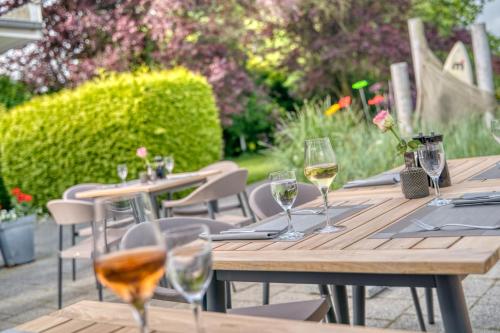 a wooden table with glasses of wine on it at Strandgrün Golf- & Spa Resort in Timmendorfer Strand