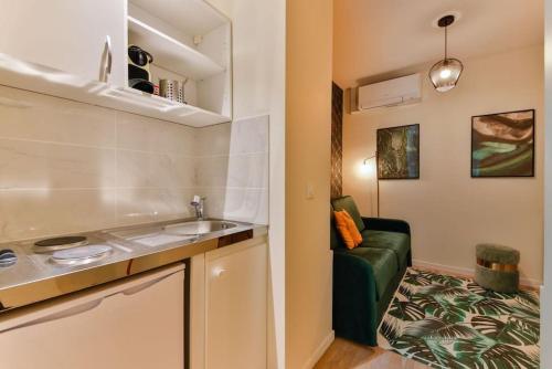 une petite cuisine avec un évier et un canapé dans l'établissement 0#Studio 2pers#Champs Elysées#Arc de Triomphe, à Paris
