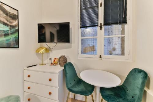 een kamer met een tafel en twee groene stoelen bij 0#Studio 2pers#Champs Elysées#Arc de Triomphe in Parijs