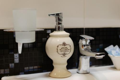 a soap dispenser sitting on top of a sink at Hotel 19 Batumi in Batumi