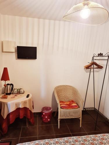 a room with a table and a chair and a tv at Le Domaine de Kerlys in Briec