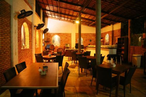 um restaurante com mesas e cadeiras num quarto em Beleza Tropical Pousada Hotel em Fortaleza