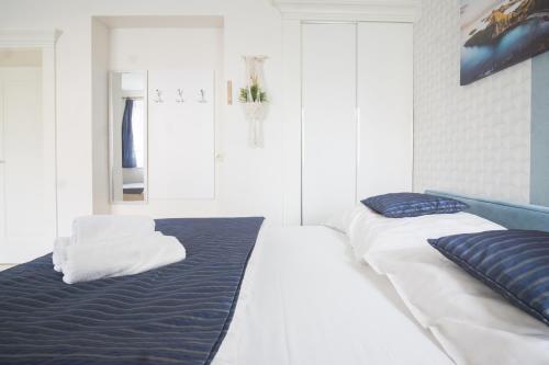 a white bedroom with two beds with blue sheets at roomsy guest house in Sopot