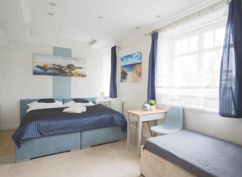 a bedroom with a bed and a desk and a window at roomsy guest house in Sopot