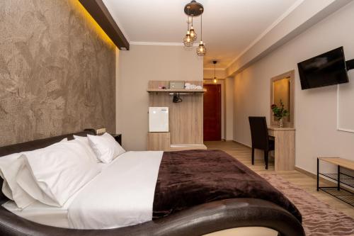 een hotelkamer met een groot bed en een bureau bij Hotel Epavlis in Drama