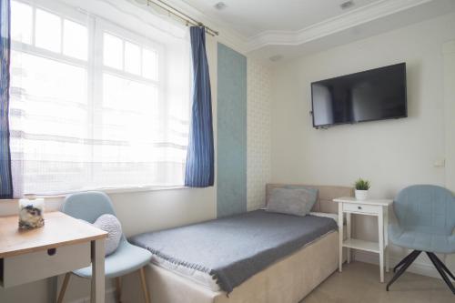 a small bedroom with a bed and a tv at roomsy guest house in Sopot